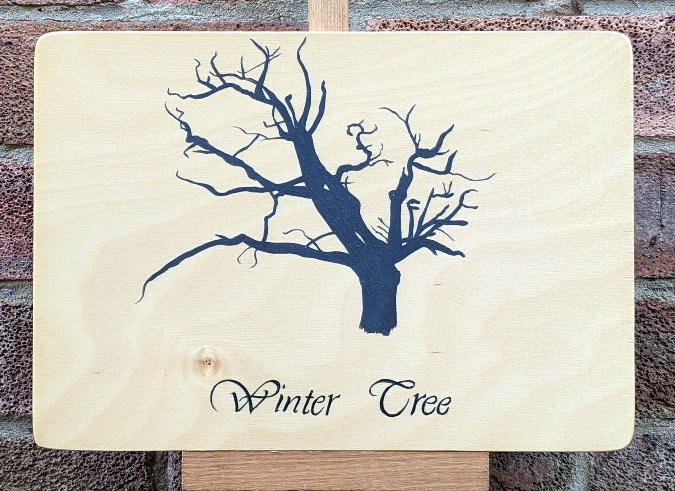Winter Tree Silhouette Silhouette of a tree trunk without leaves with 'Winter Tree' signwritten in black upon a maple plywood panel.