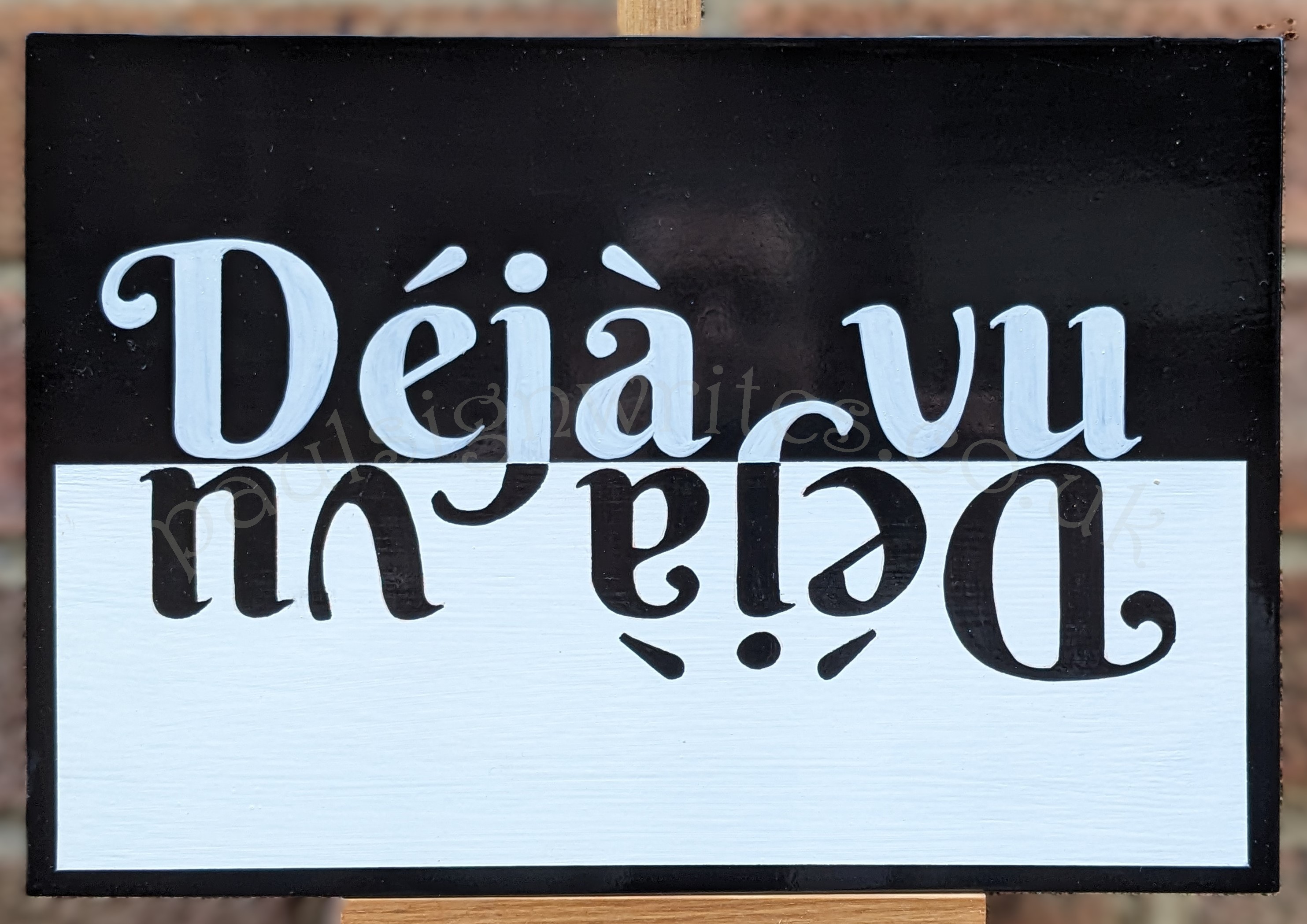 Déjà-vu black and white flip over hand painted sign.