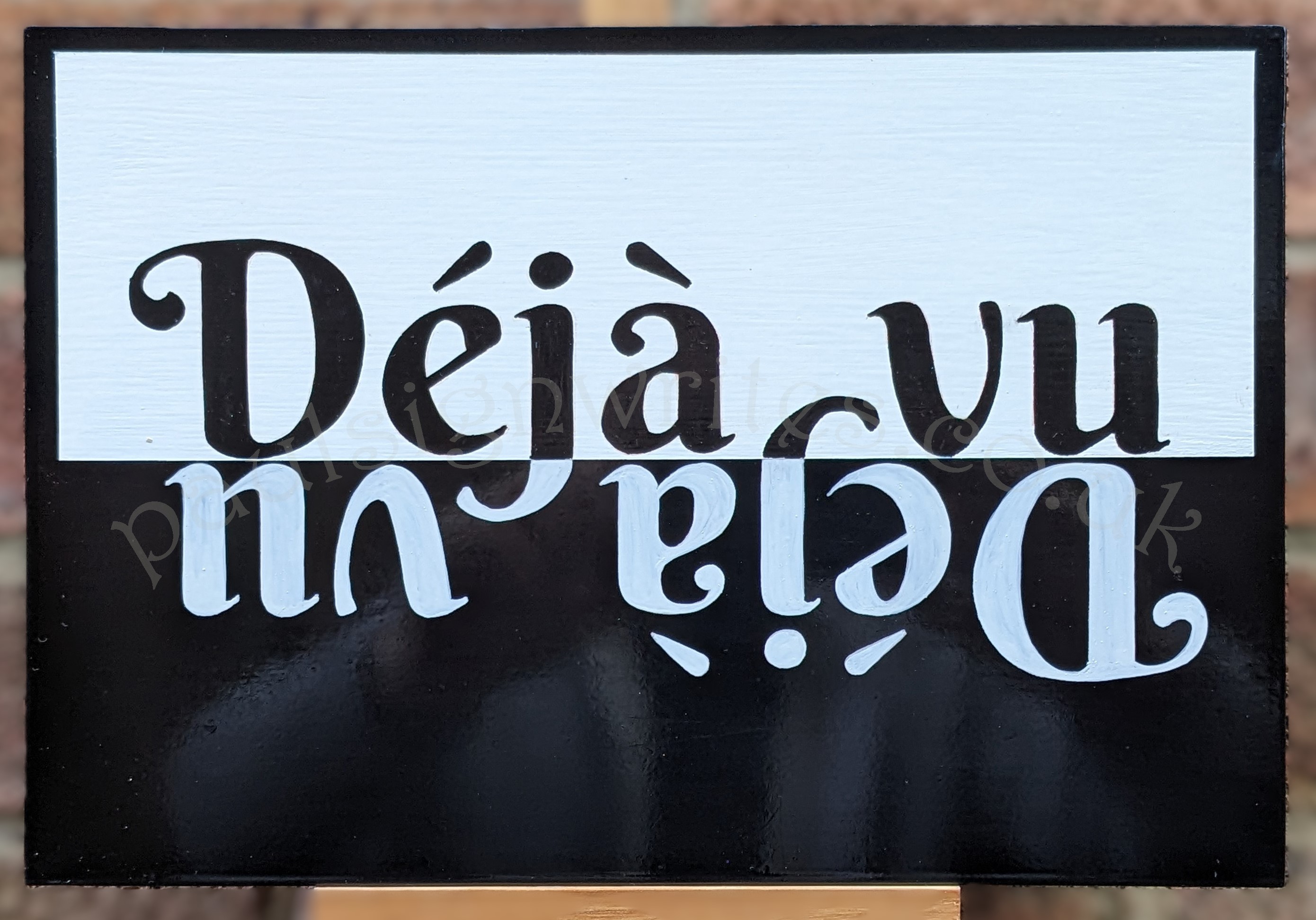 Déjà-vu black and white flip over hand painted sign.
